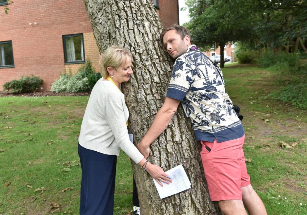 Two conference attendees hugging a tree.