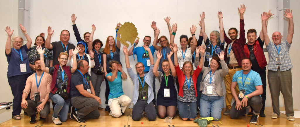 Photo from the Playful Learning conference of the winning Blue team waving.