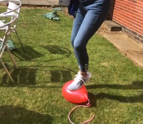 Photo of someone popping a balloon by standing on it