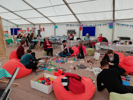 Photo of adults using Lego in a tent